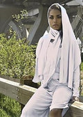 Front view of a model wearing the white short MooreWrap jumpsuit outdoors