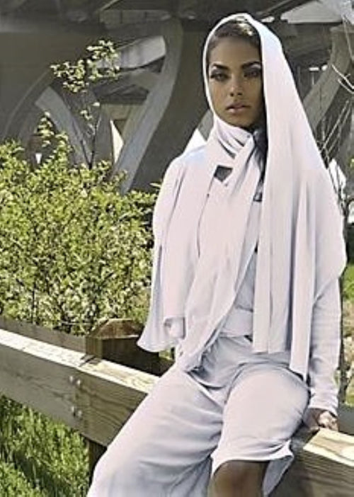 Front view of a model wearing the white short MooreWrap jumpsuit outdoors